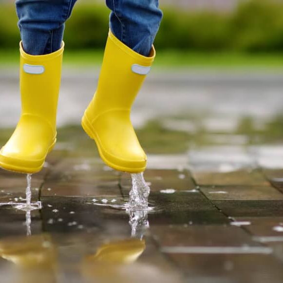 Toddler jumping in pool of water at the summer or autumn day. Outdoors activity for kids.